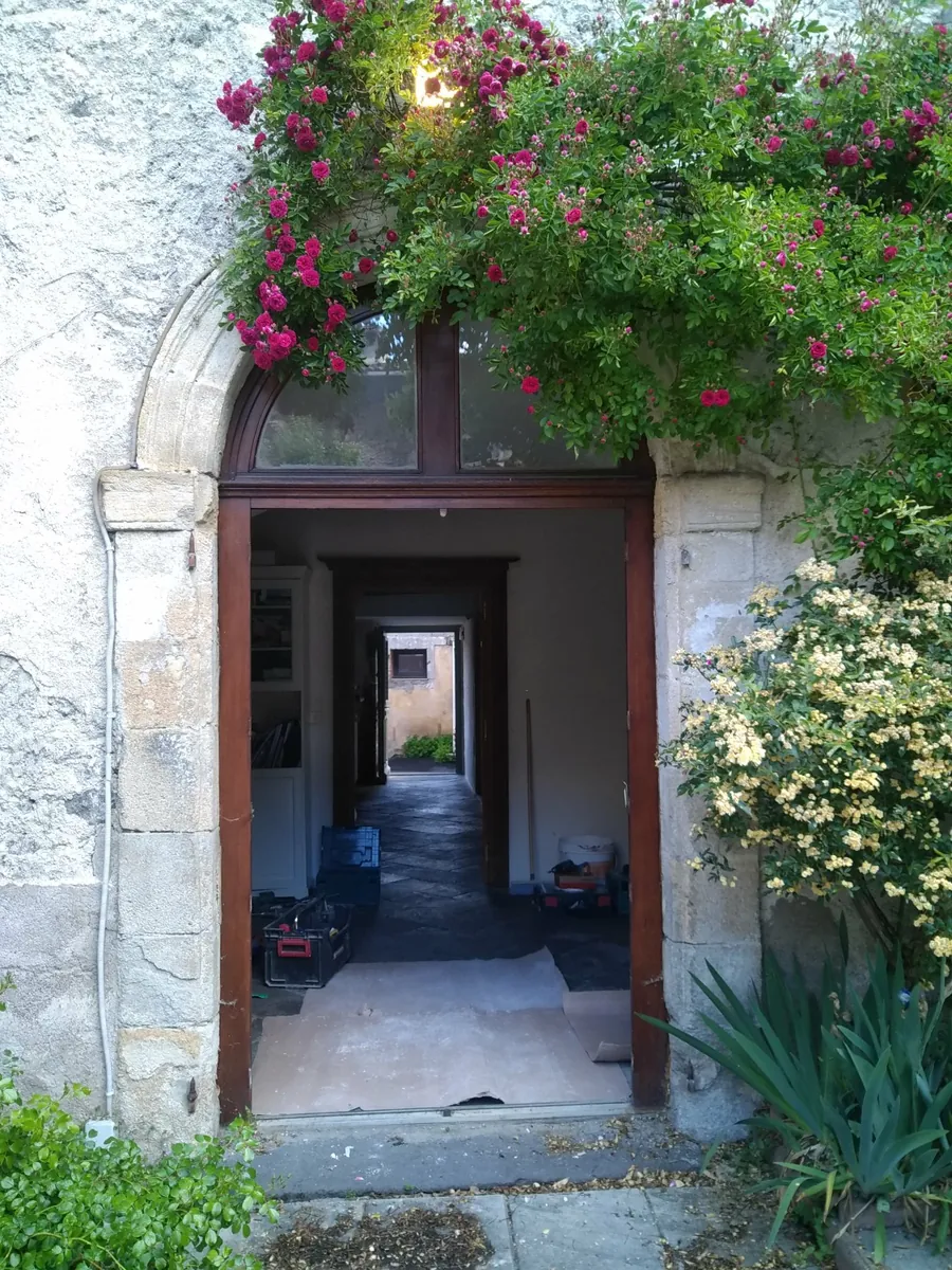 Avant travaux avec ancienne menuiserie bois cintrée à remplacer sur une bâtisse ancienne en pierre